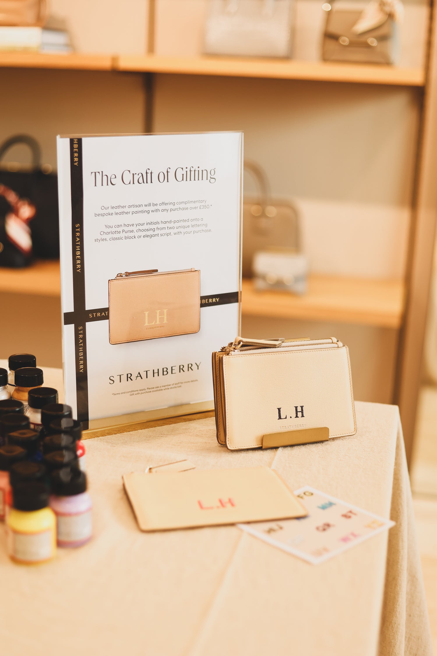 Live leather personalisation service with custom initials on luxury Strathberry leather goods