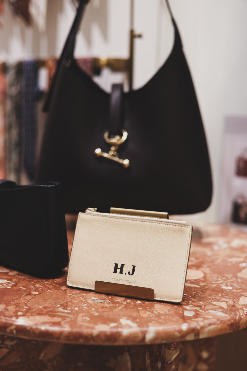 Strathberry leather card holder featuring bespoke hand-painted initials, showcasing luxury leather personalisation and monogram artwork by Aivis Provejs.