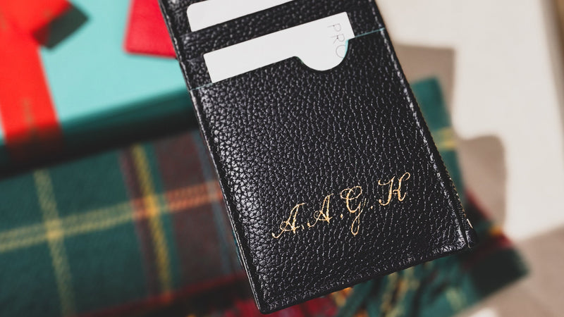 Personalised Fortnum & Mason leather card holder with hand-painted gold calligraphy initials by Aivis Provejs, bespoke luxury leather personalisation.